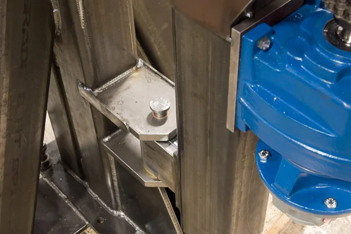 Fabricated stainless mount holding a blue drive unit
