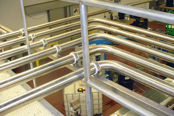 Stainless pipe runs on an overhead support frame